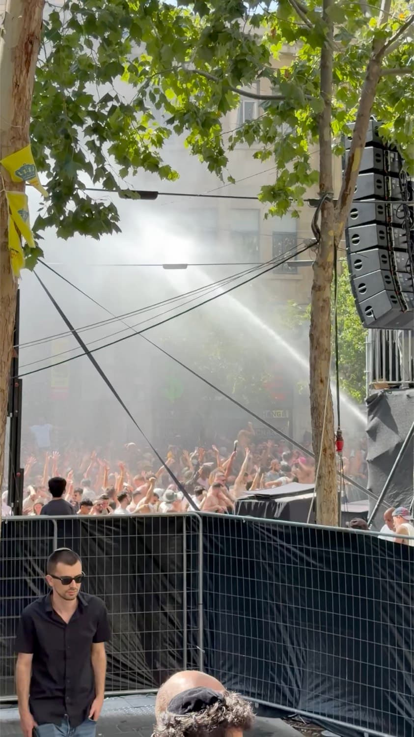 An open-air summer music event with misting water over the crowd in central Jerusalem